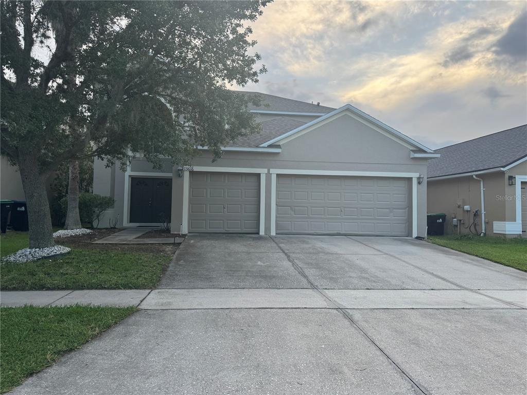 front view of a house with a yard and garage