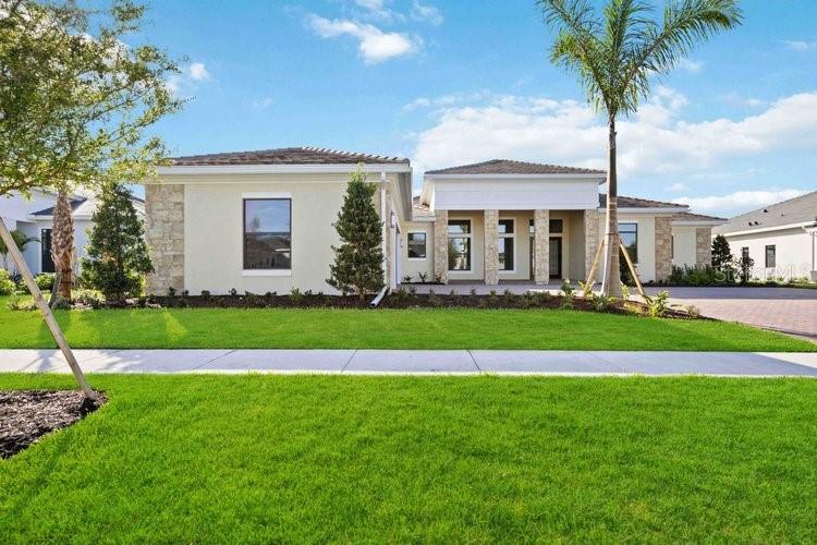 a front view of a house with a yard and palm trees