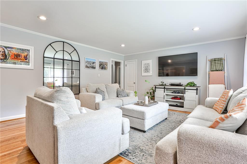 a living room with furniture a flat screen tv and a window