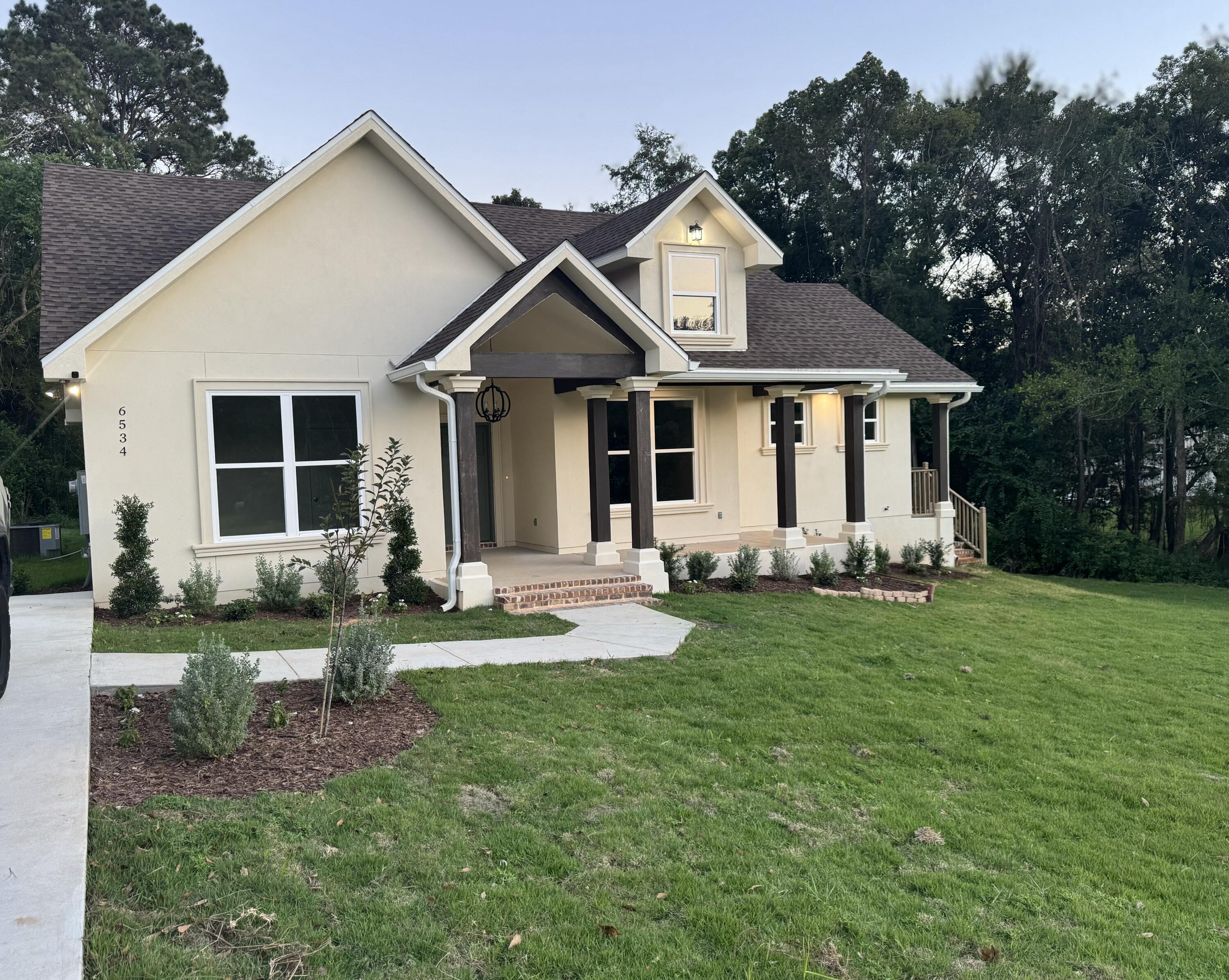 a front view of a house with a yard and porch