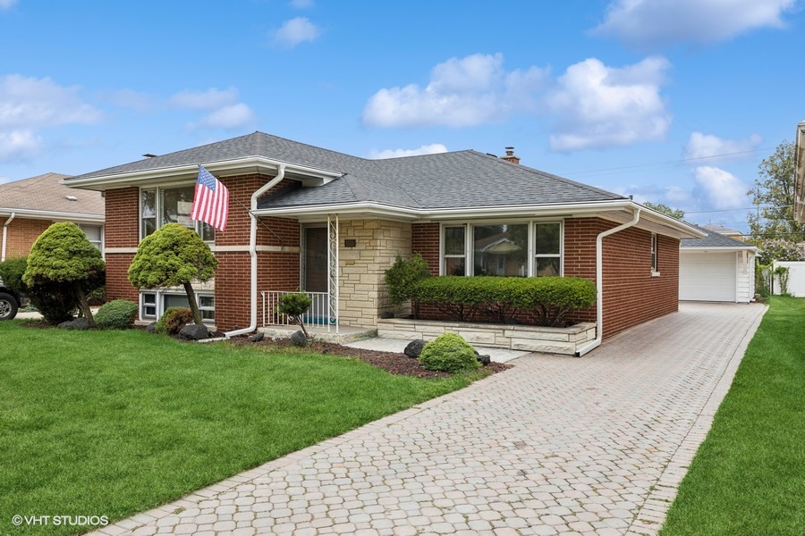 a front view of a house with a garden and plants