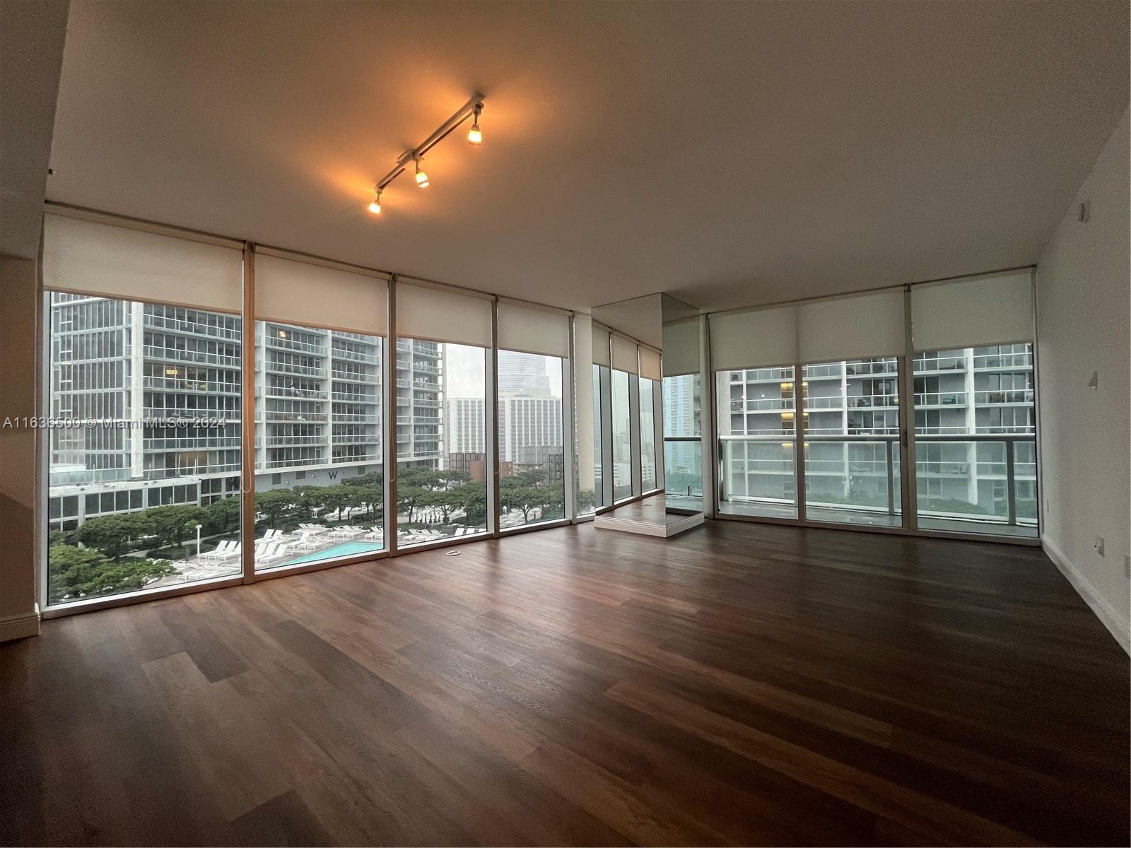 a view of a room with wooden floor and large window