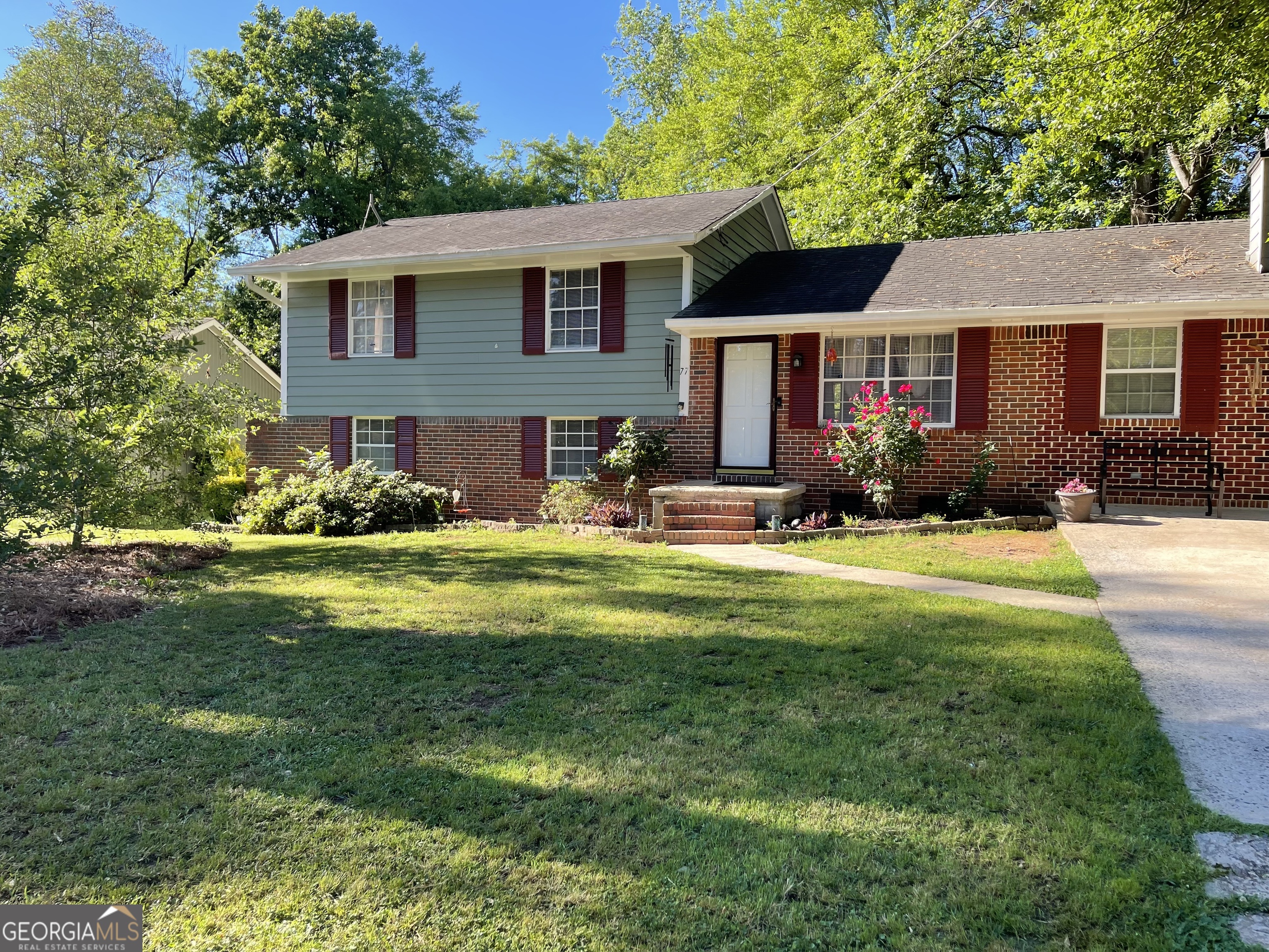 a front view of a house with a yard and trees