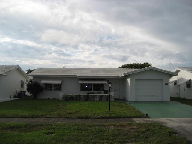 a view of a white house with a yard and plants