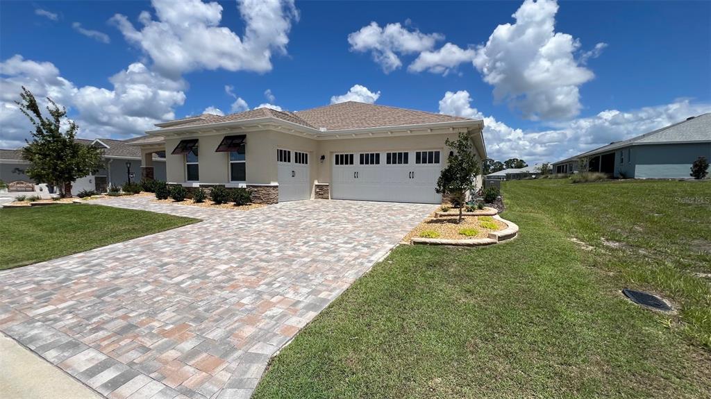 a front view of a house with a garden and yard