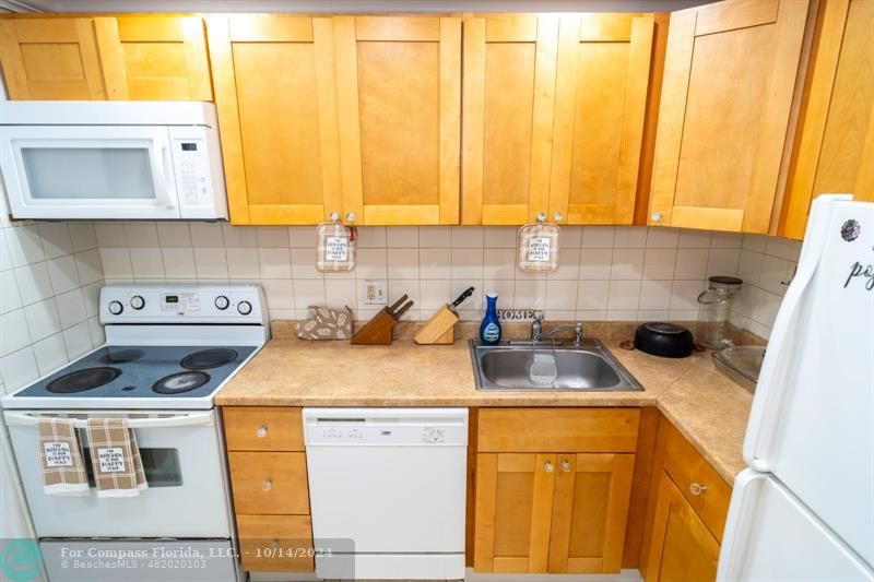 a kitchen with a sink a stove and cabinets