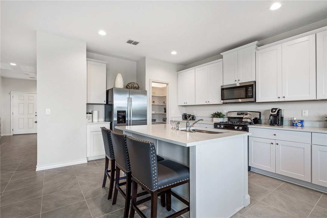 a kitchen with white cabinets stainless steel appliances and sink