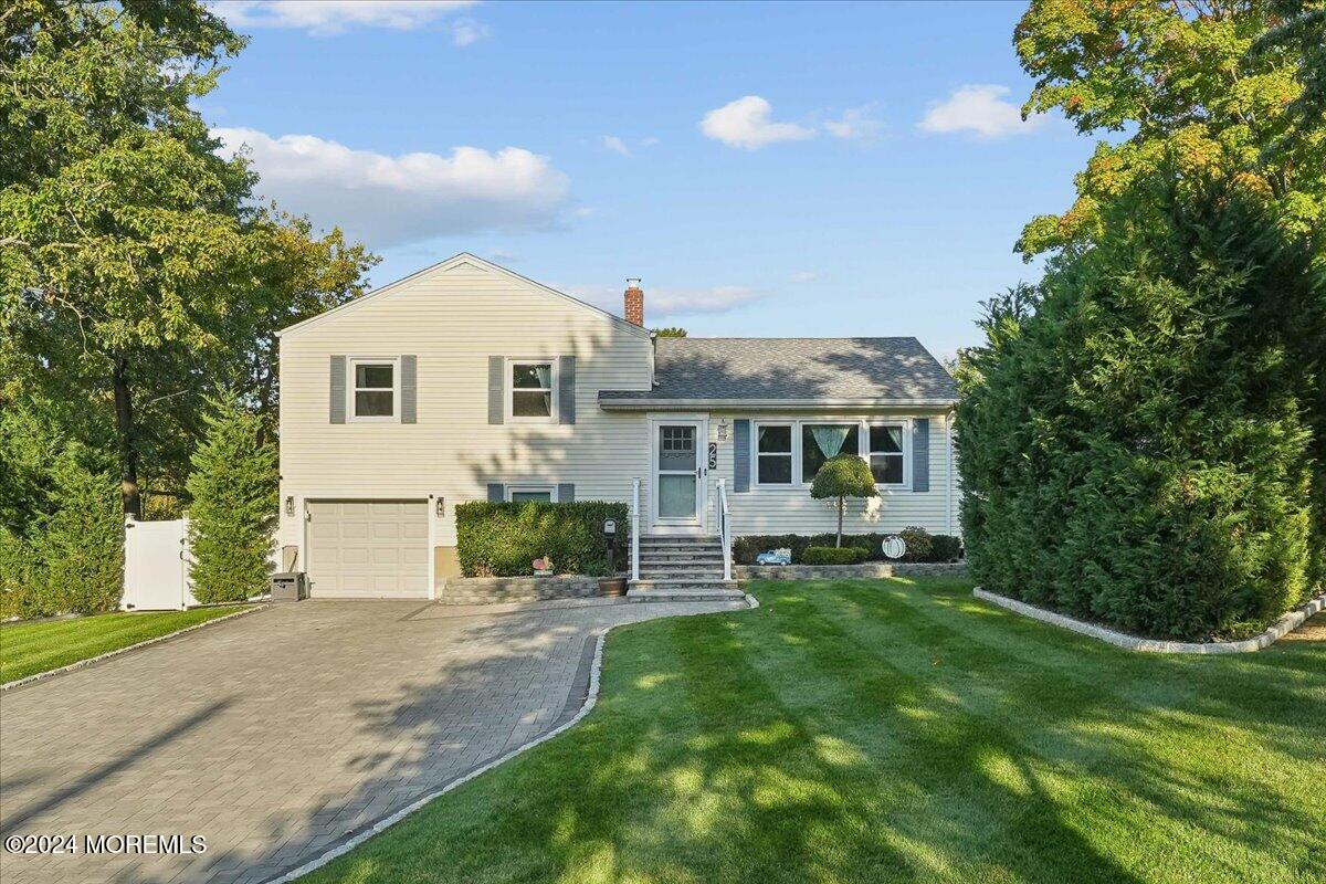 a front view of a house with a garden and yard