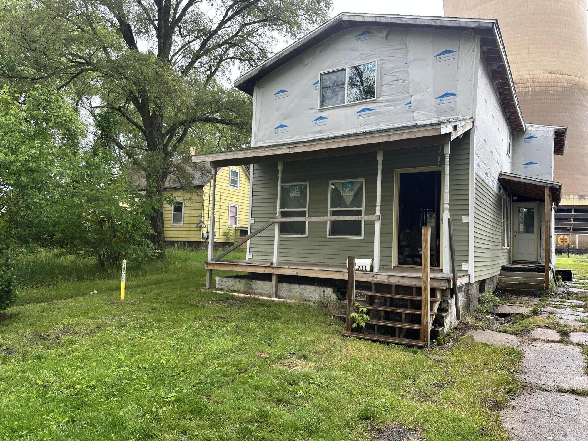 a view of house with a yard and sitting area