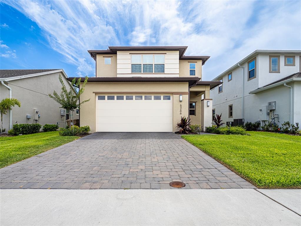 a front view of a house with a yard and garage