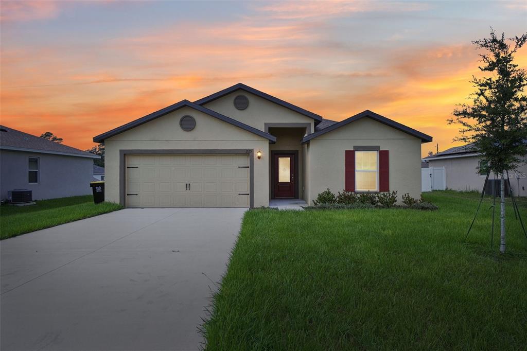 a front view of a house with a yard and garage