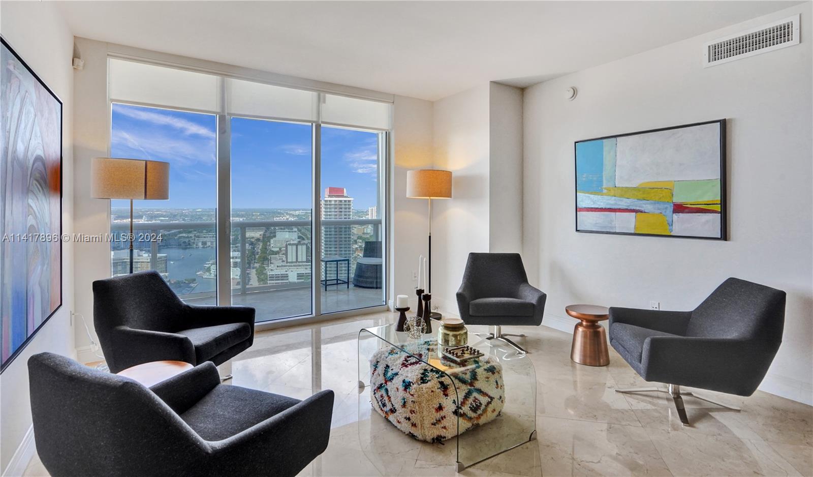 a living room with furniture and floor to ceiling windows