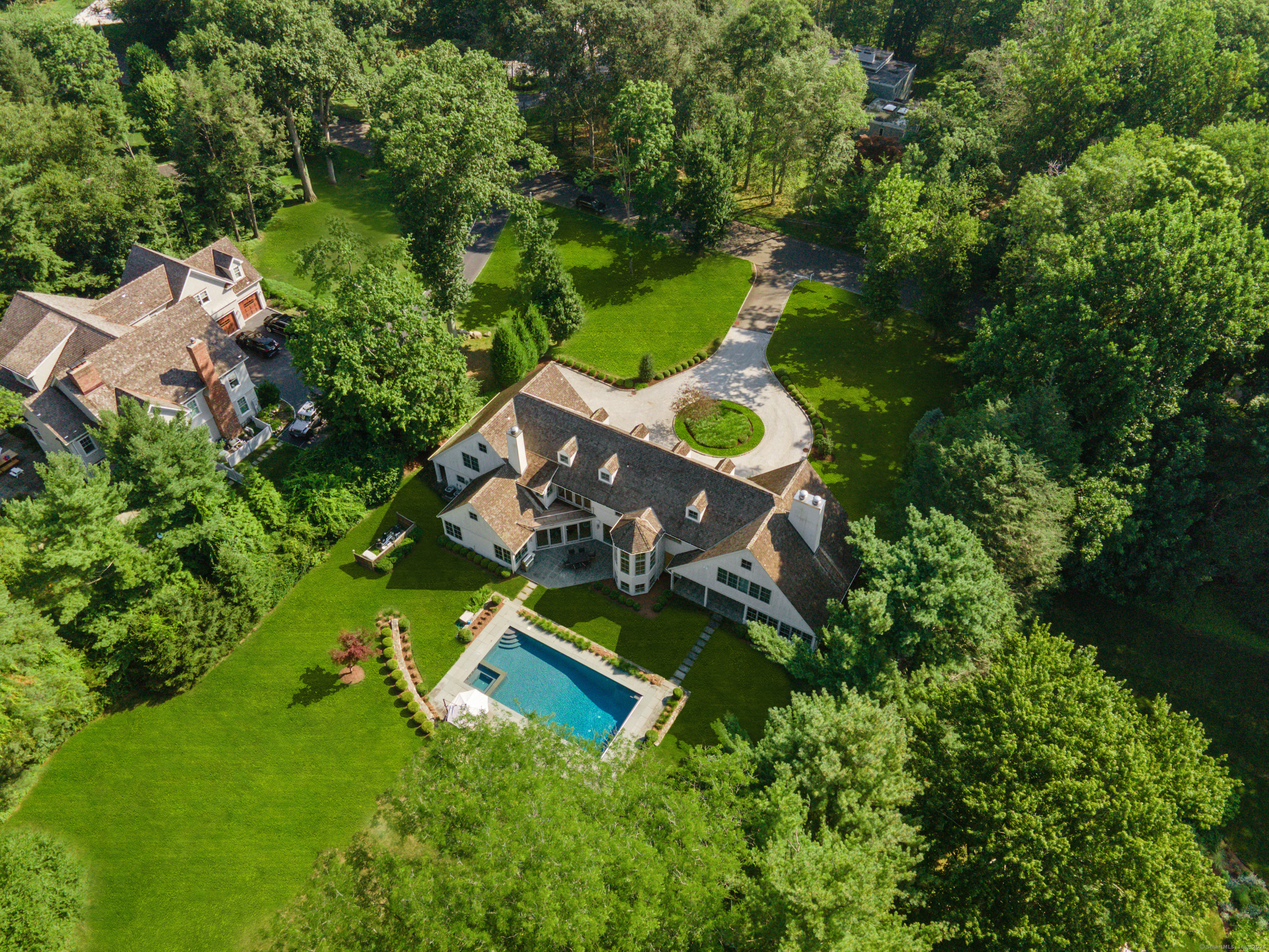 an aerial view of a house with swimming pool and garden