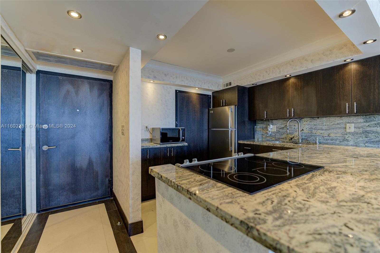 a kitchen with a sink a refrigerator and cabinets