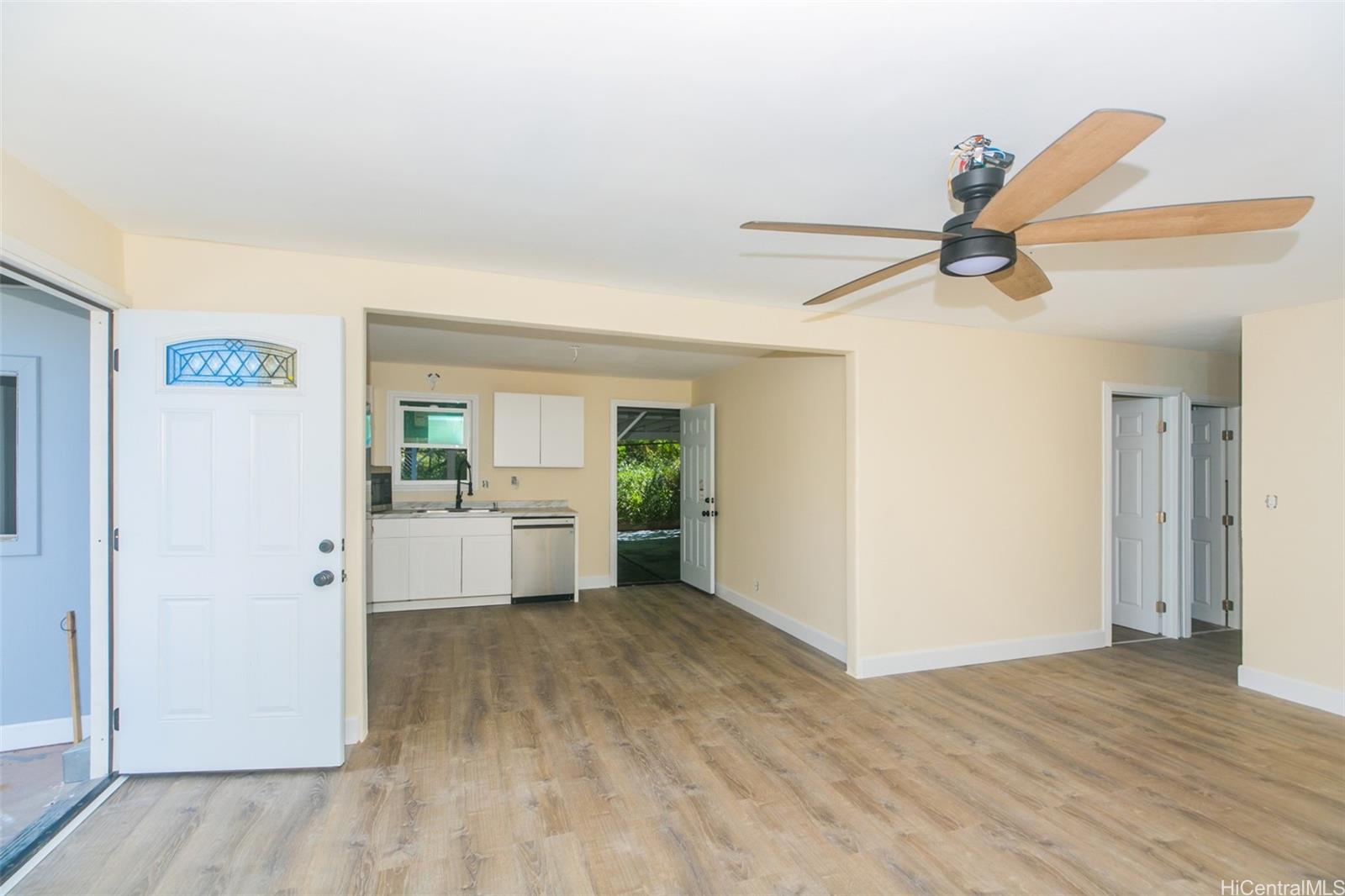 a view of a livingroom with wooden floor and a ceiling fan