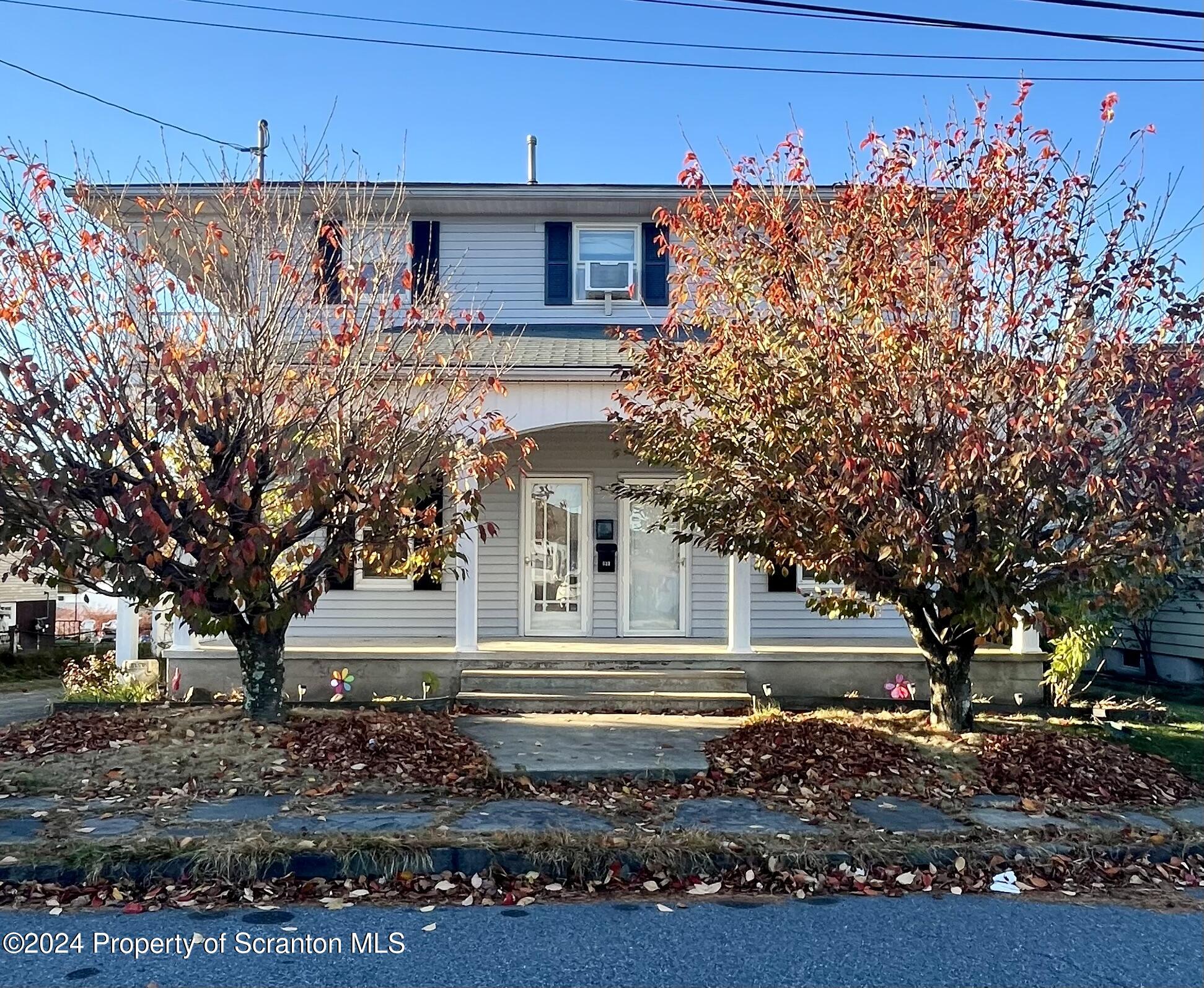 a view of a house with a tree and a yard