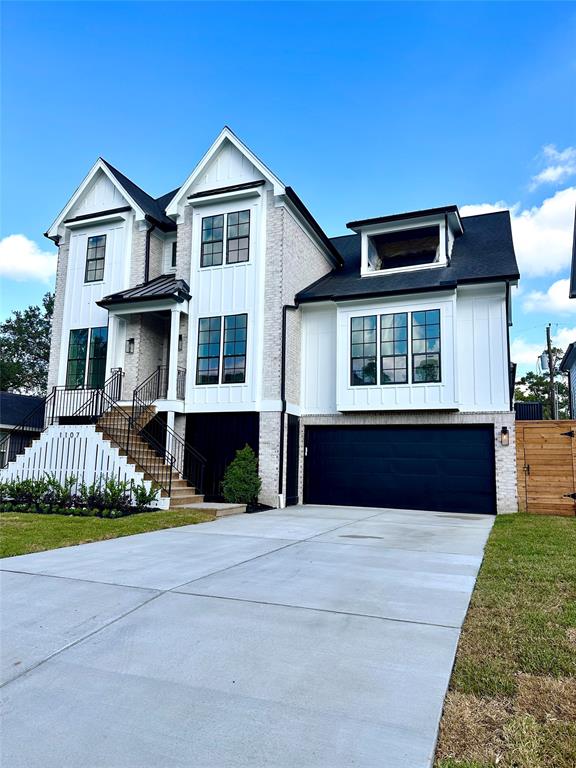 Picture update 10/28/24. The elevated entry with wide steps adds curb appeal, while the clean landscaping and large driveway provide an inviting first impression.