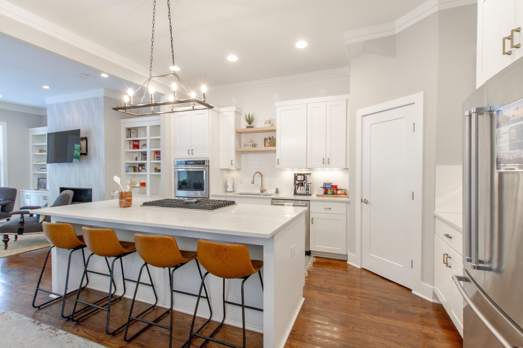 a kitchen with stainless steel appliances kitchen island granite countertop a table chairs and a refrigerator