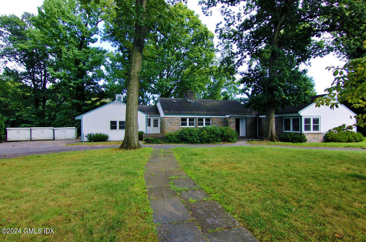 a front view of a house with a yard and trees