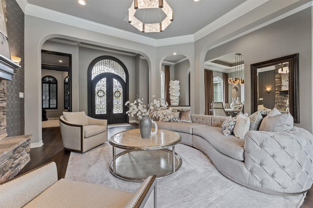 a living room with furniture chandelier and a large mirror