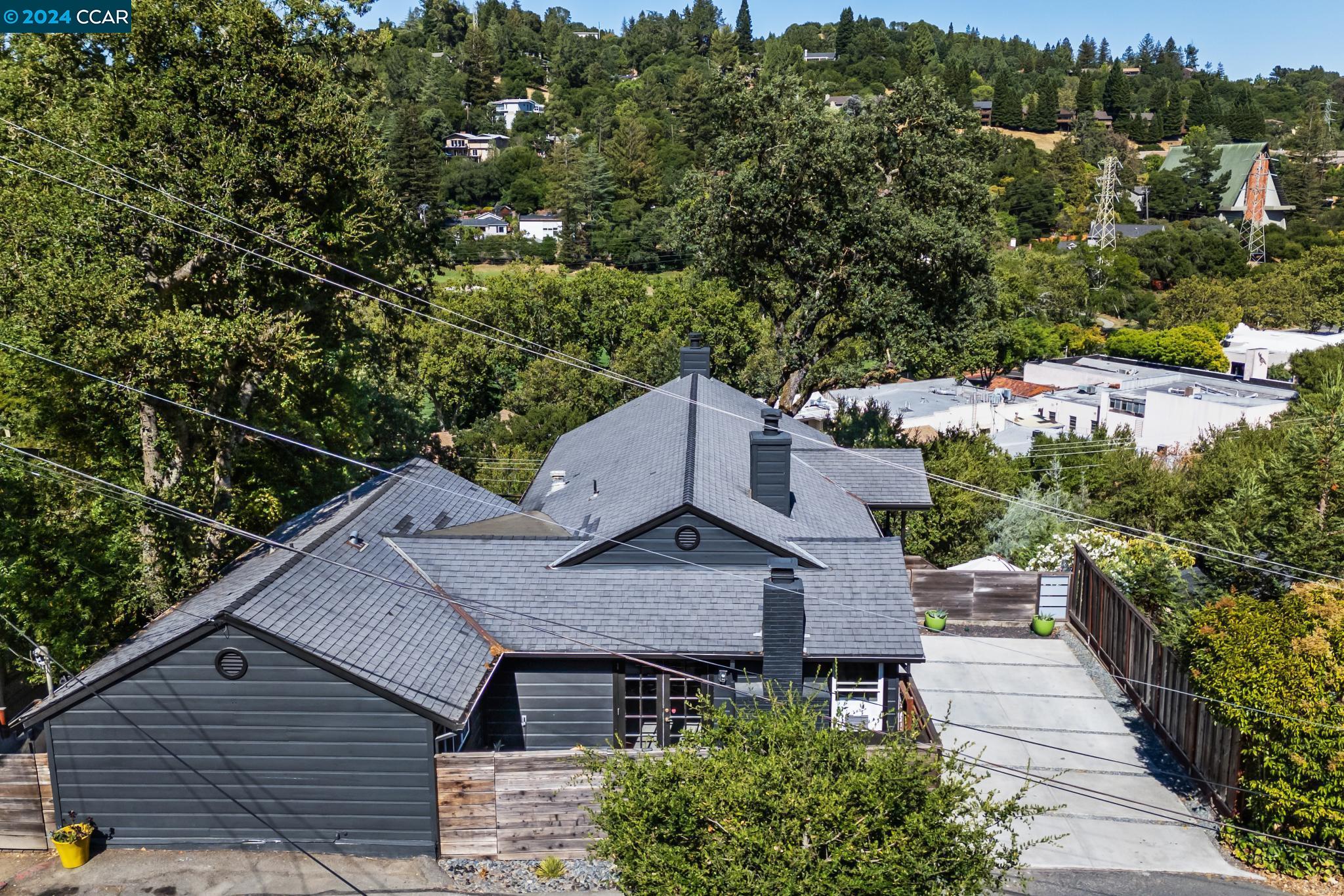 an aerial view of a house with a yard and mountain view in back