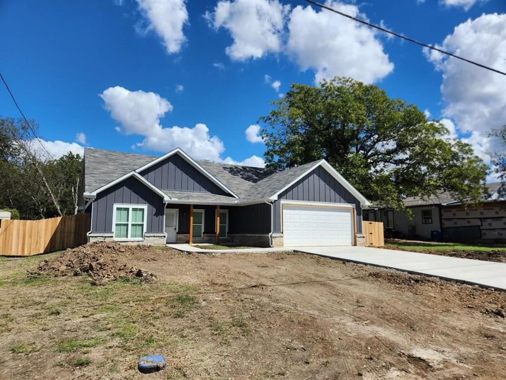 a front view of a house with a yard and trees