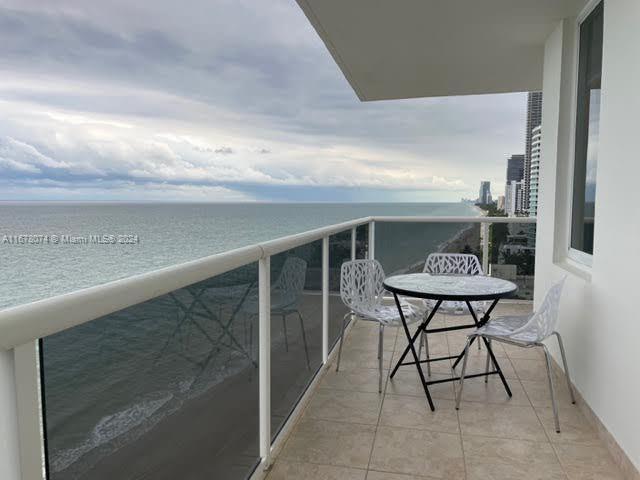 a balcony with table and chairs