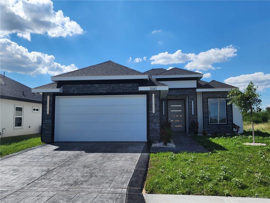 a front view of a house with a yard and garage