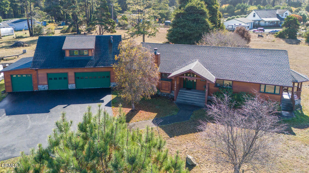 a view of a house with a yard and large tree