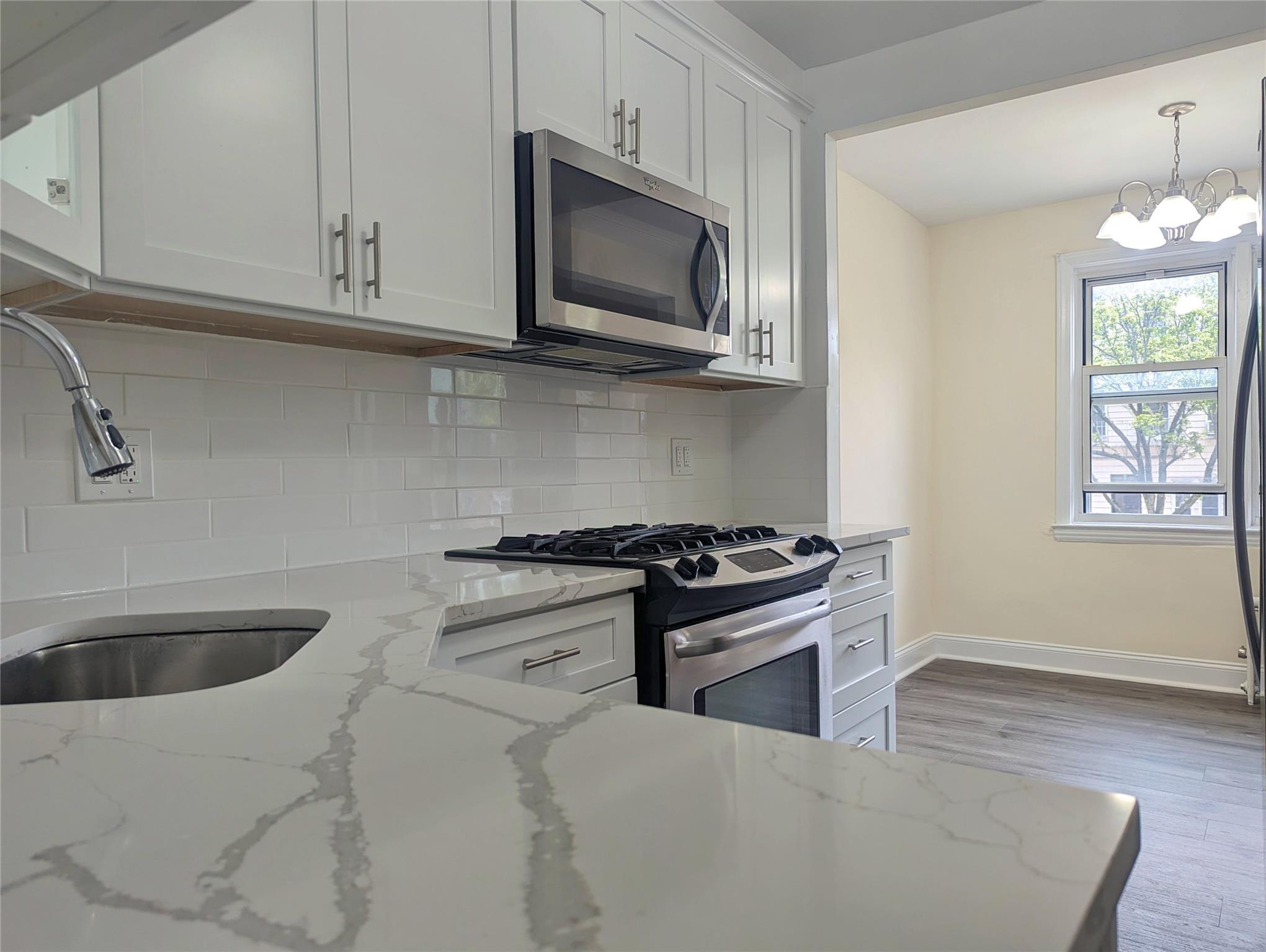 a kitchen with stainless steel appliances granite countertop a sink and a stove