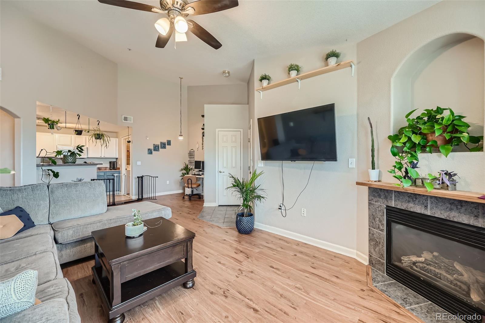 a living room with furniture a flat screen tv and a fireplace