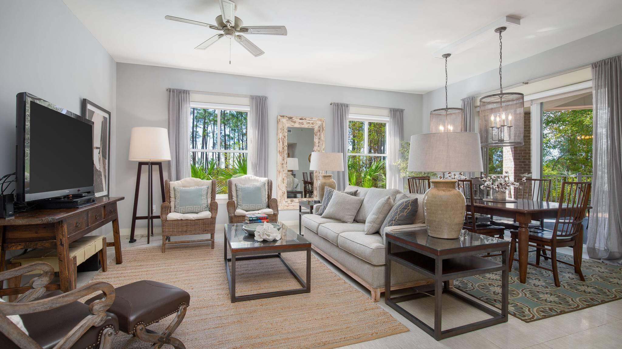 a living room with furniture a flat screen tv and a large window