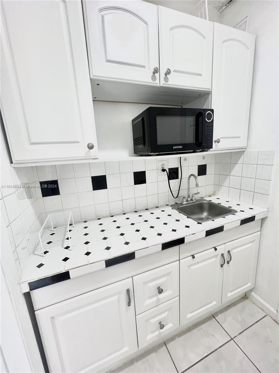 a kitchen with granite countertop a sink and a stove top oven