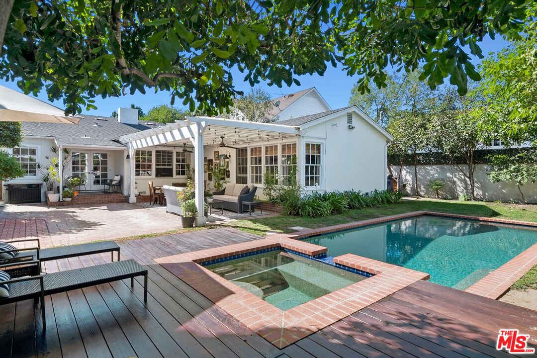 a view of a house with pool lawn chairs and wooden floor