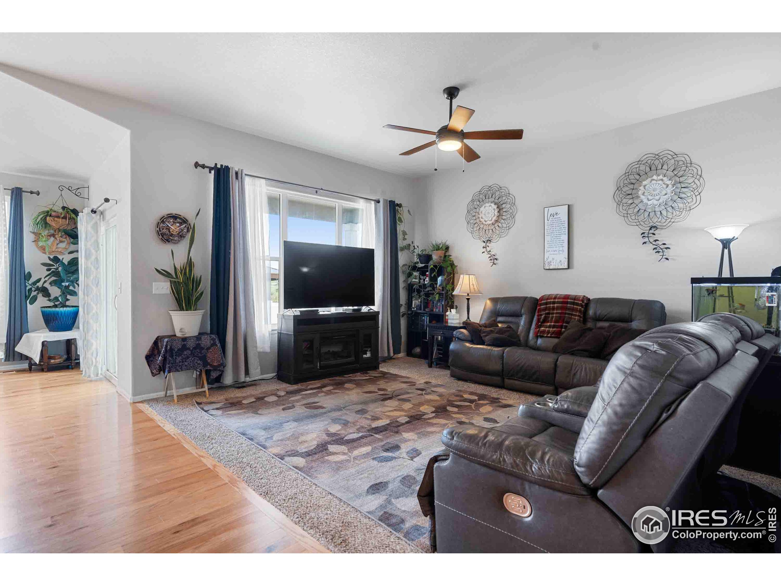 a living room with furniture a flat screen tv and a large window