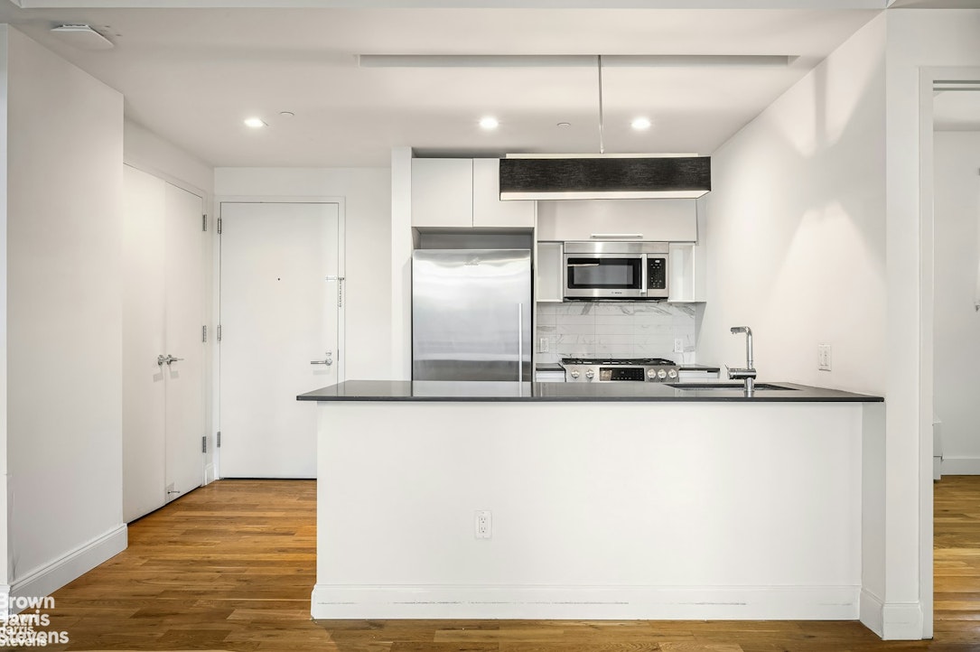 a kitchen with stainless steel appliances granite countertop a sink and a stove top oven