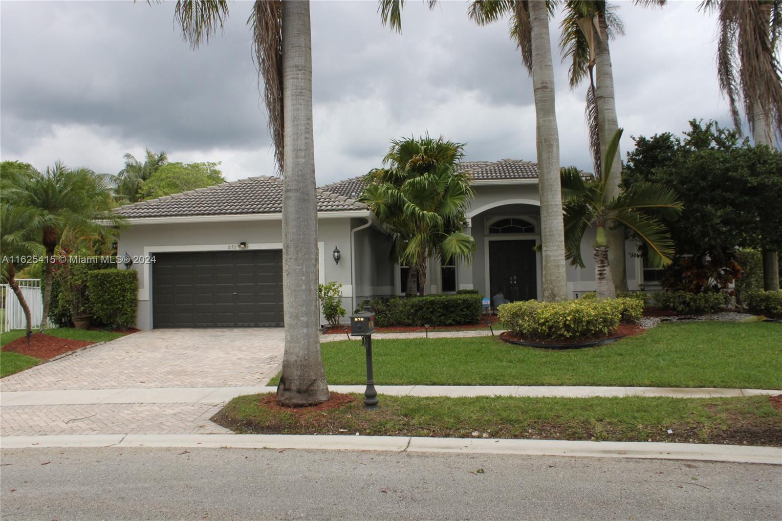 a front view of a house with a garden and yard