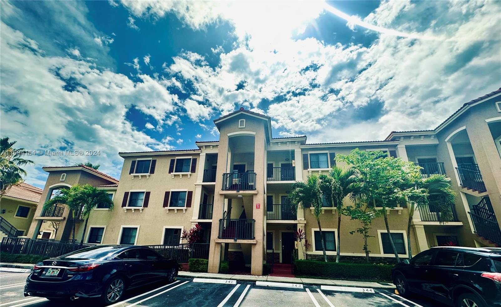 a front view of a residential apartment building with a yard