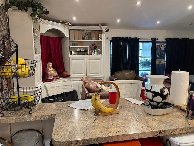 a living room with furniture a rug and kitchen view