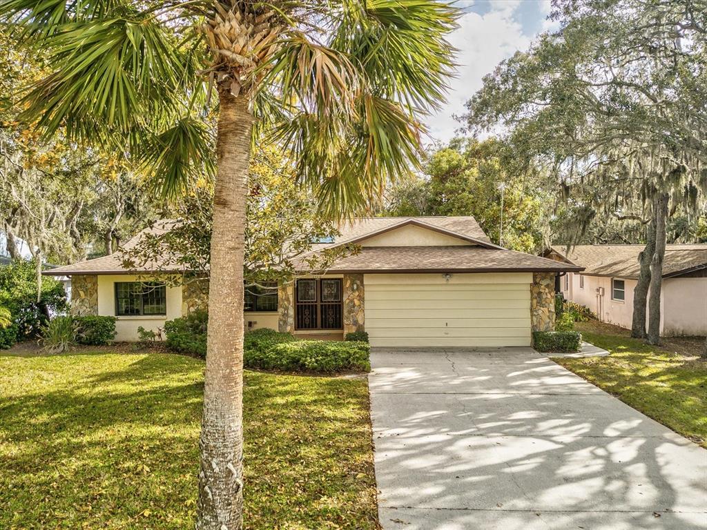 a front view of house with yard and trees around