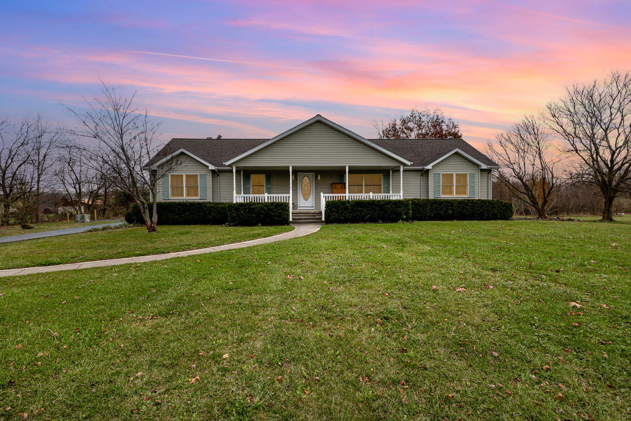 a view of a house with a big yard and large trees