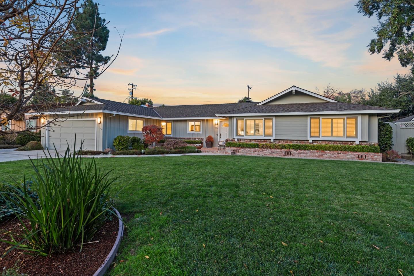 a front view of a house with a yard and potted plants