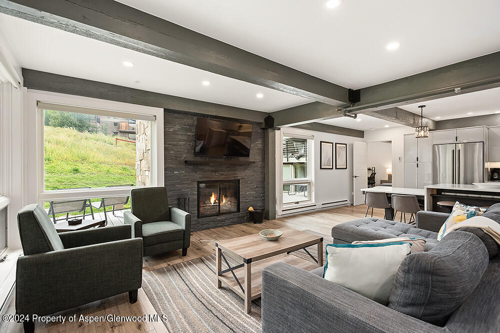 a living room with furniture fireplace and a large window