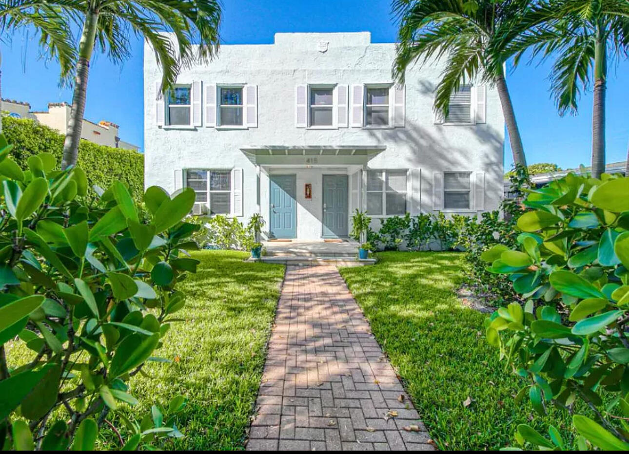 a front view of a house with a garden