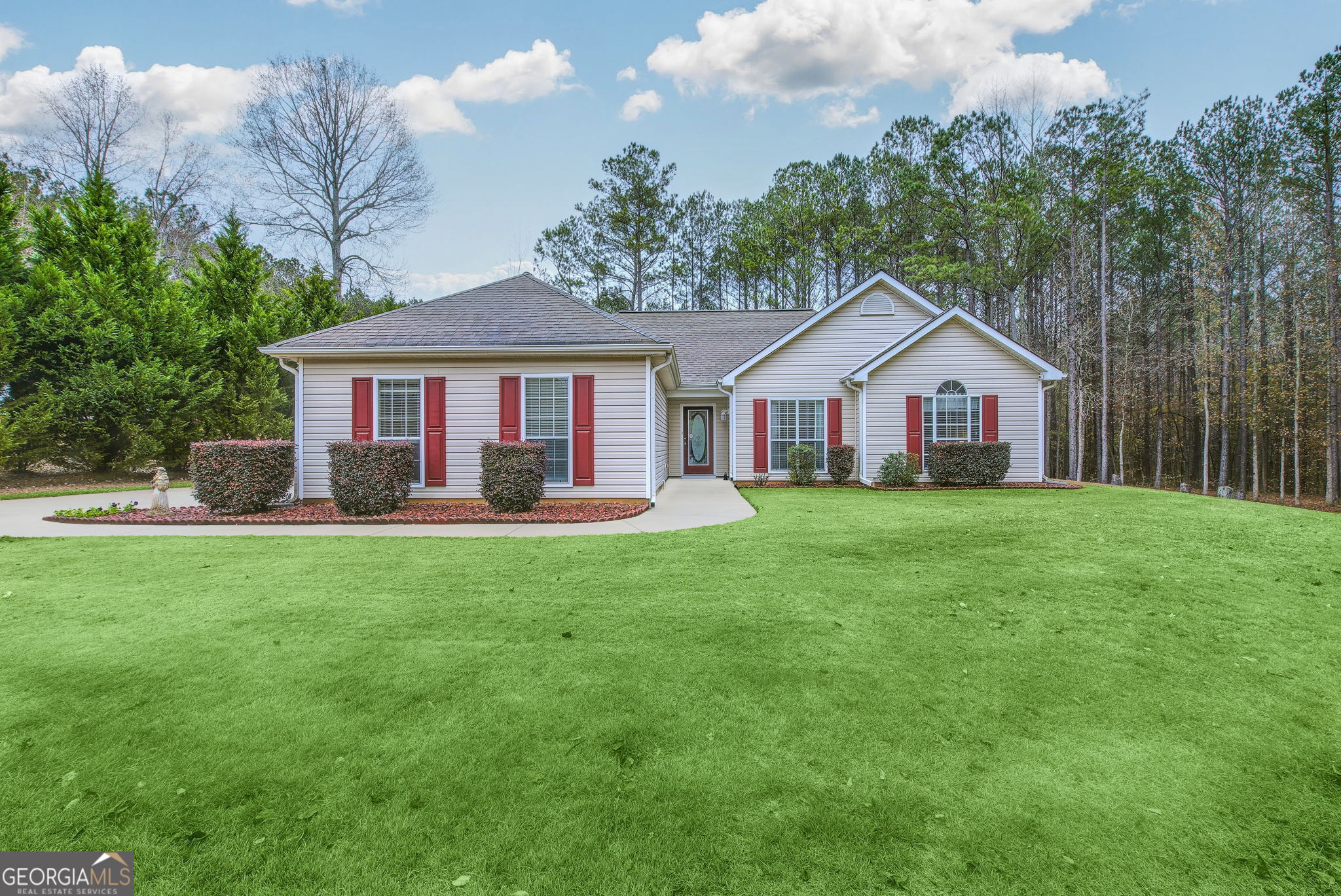 a front view of a house with a yard and green space