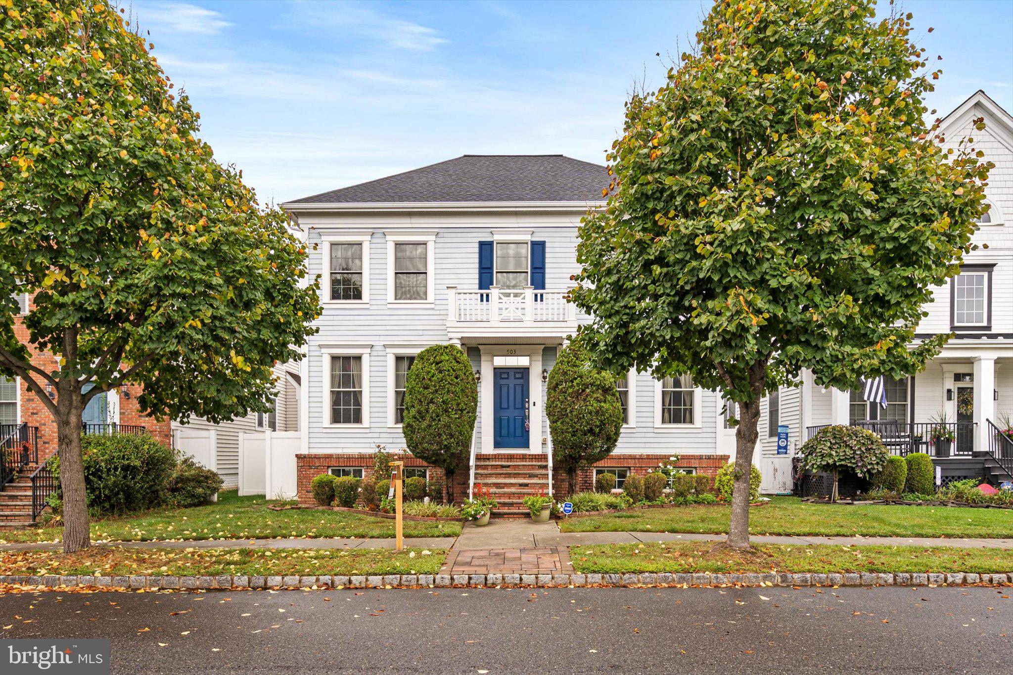 a front view of a house with a garden and tree