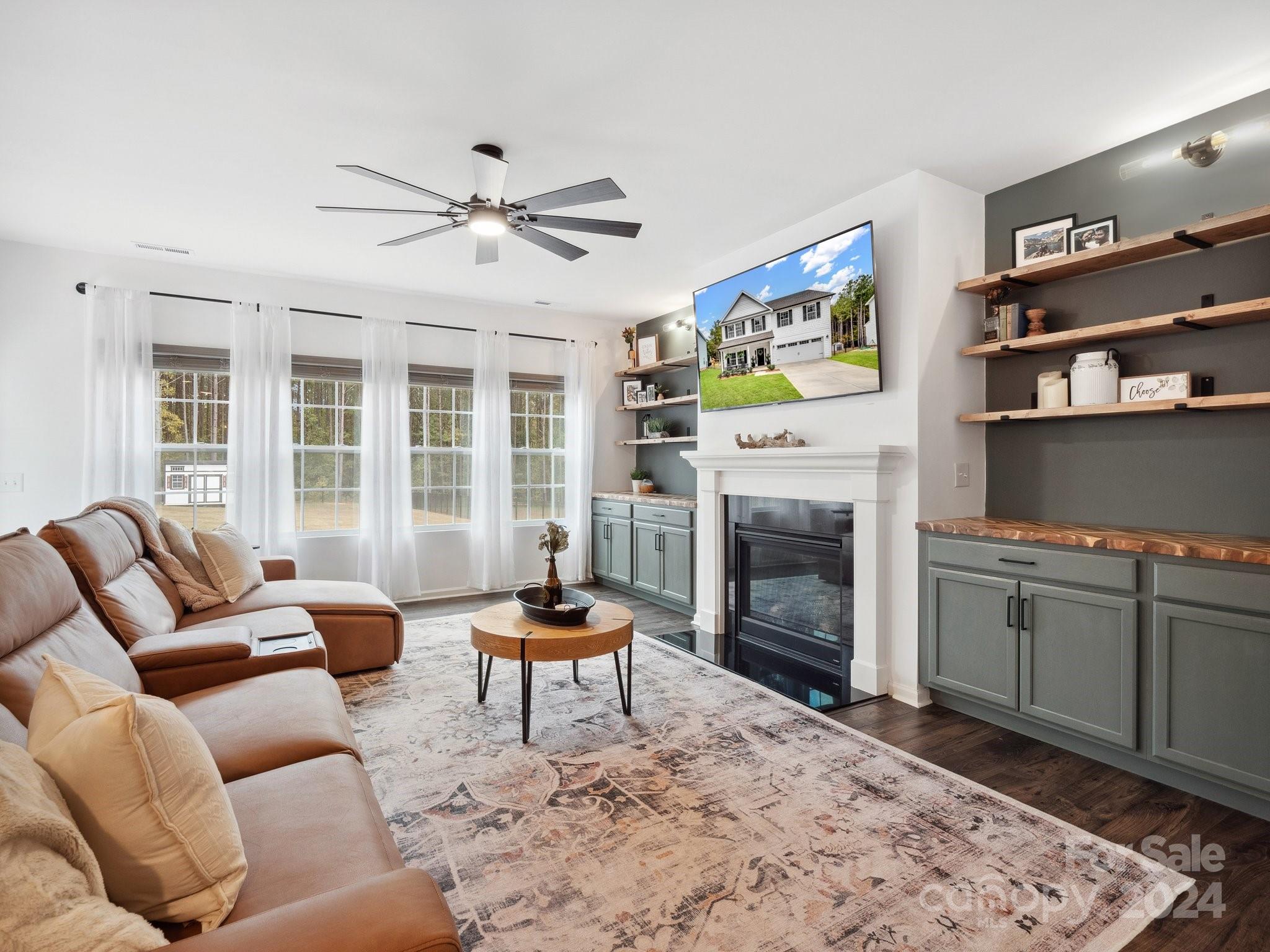 a living room with furniture a fireplace and a flat screen tv