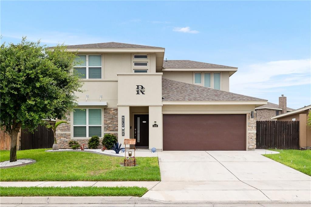 a front view of a house with a yard and garage