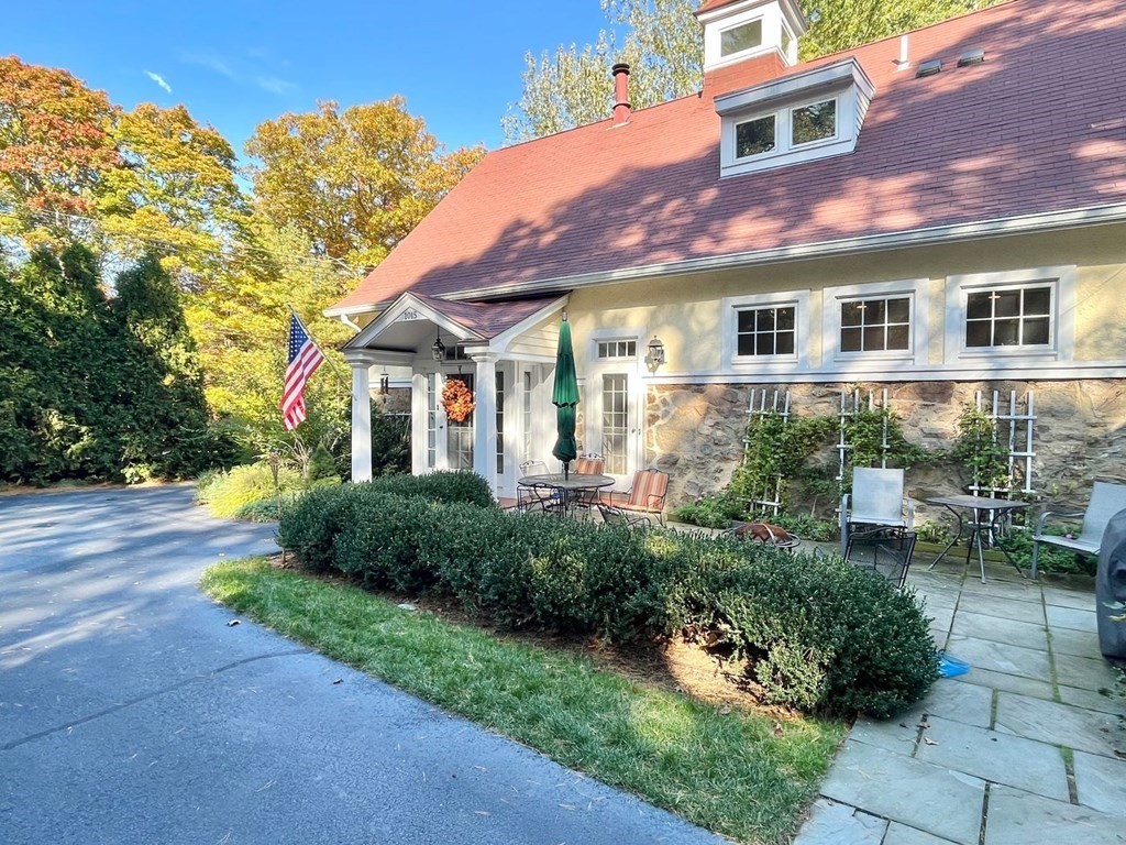 a front view of a house with a yard and potted plants