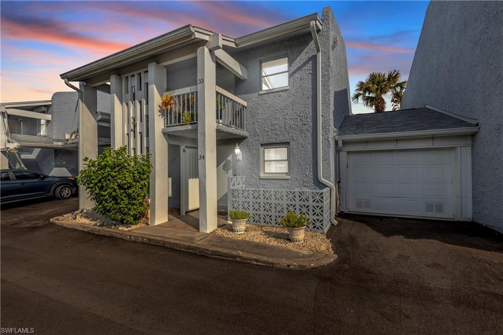 View of front of property with a balcony and a garage